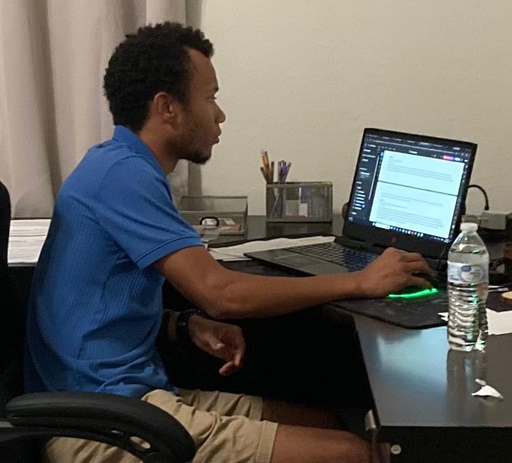 Dom Kemp working at his desk on a laptop